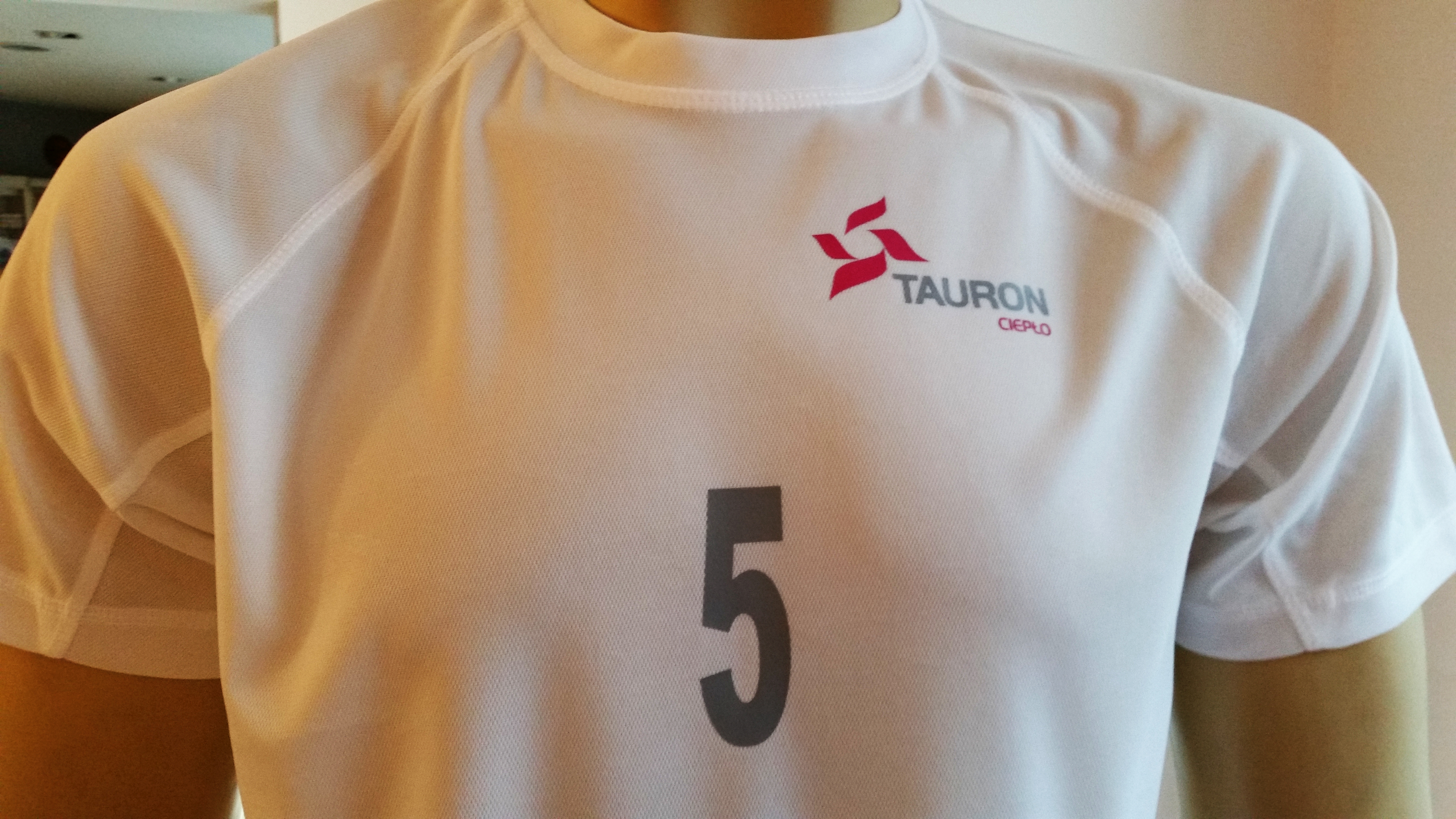 mały numer i logo TAURON na koszulkach treningowych